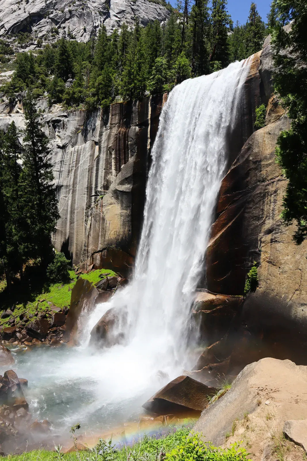 A big waterfall with a rainbow at its base.